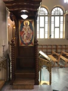 العرش البطريركي نجارة وتقدمة ” باوندي السنة 1936 وحفر فارس زيتون وابنيه نقولا وجورج وبجانبة طاولة حفر وتقدمة جورج زيتون لراحة نفسي والديه فارس واسما ويمينه حاملة ايقونة من اثنتينحفر وتقدمة جورج زيتون عن صحته وصحة زوجته روزيت وبجانبه حاملة ايونة عمل المبدع جورج وتقدمته