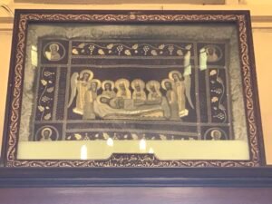 صورة النعش السيدي الأبيطافيون مطرزة حفر الفنان جورج زيتون منارة بالنور الكهرباء تقدمتي لراحة نفس شقيقي الشهيد مروان زيتون موضوعة فوق باب كنيسة الصليب المقدس الرئيس