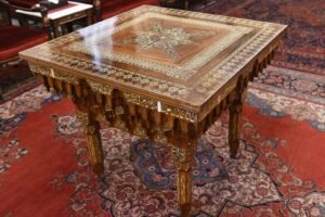 ترس الطاولة المربعة البديعة الموجودة في الصالون البطريركي والمصنوعة من عبده النحات واهداء منه الى البطريرك ملاتيوس الدوماني عام 1901 وفي كل زاوية تطويبة من التطويبات