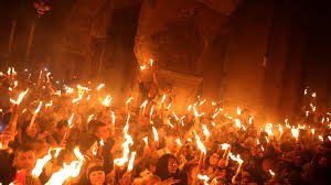 الشموع المشتعلة من النور المقدس بيد المؤمنين